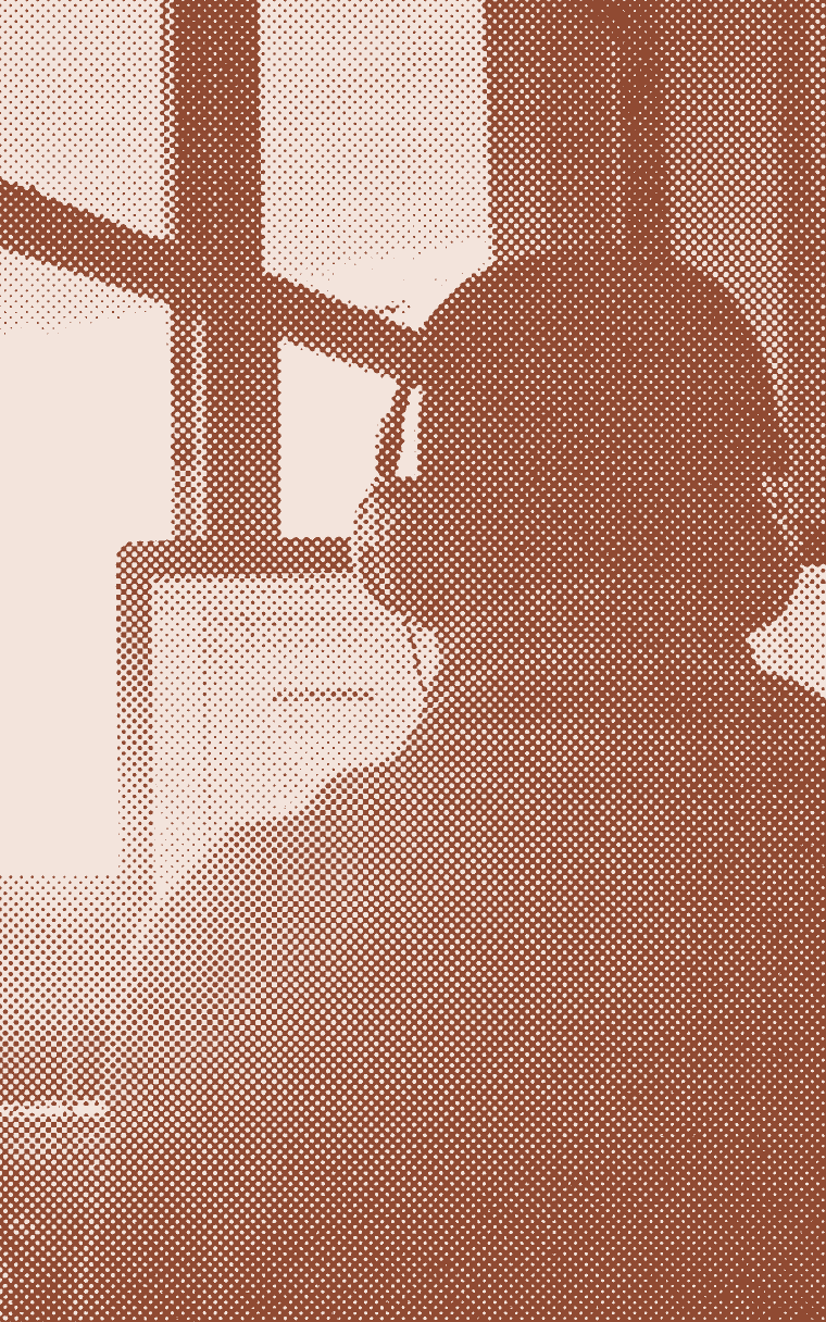 Someone in headphones on a call at a desk by a window