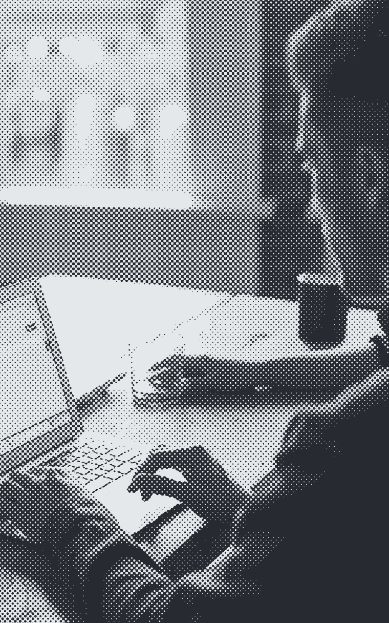 Someone typing at a laptop on a table by a window