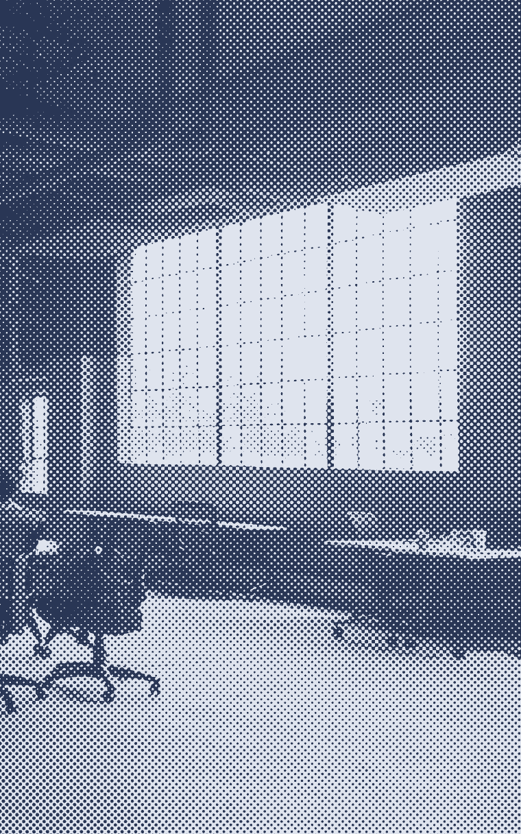 One person working in a large, quiet loft with factory windows