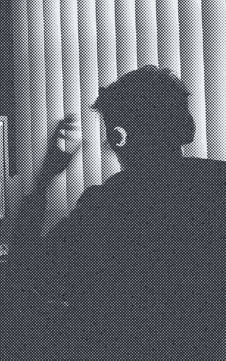 Someone in headphones working at a monitor in a dark room