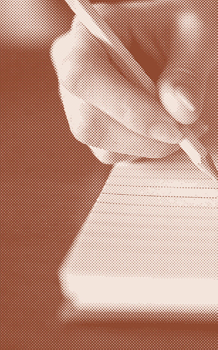 A hand writing with a pencil in a spiral notebook